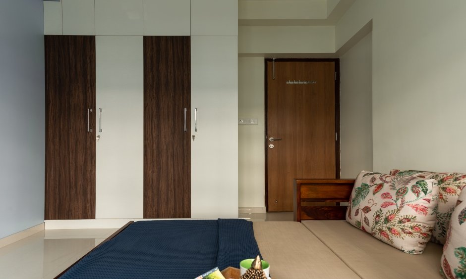 Bedroom comes in a white colour scheme, a wall to ceiling wardrobe designed by best budget interior designers in mumbai