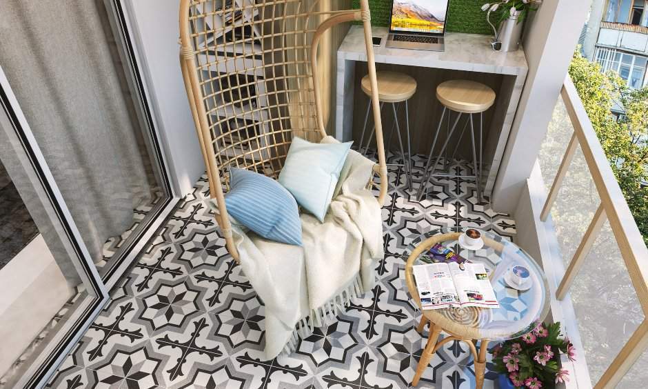 A hanging wicker swing decorated with cushions in balcony