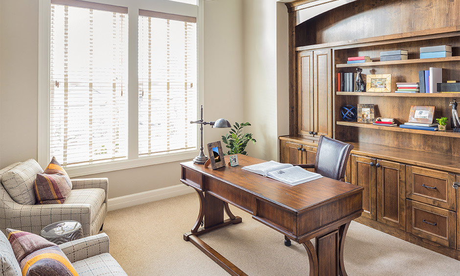 Home office interior design featuring soft furnishings, bookshelves, and fabric wall hangings.