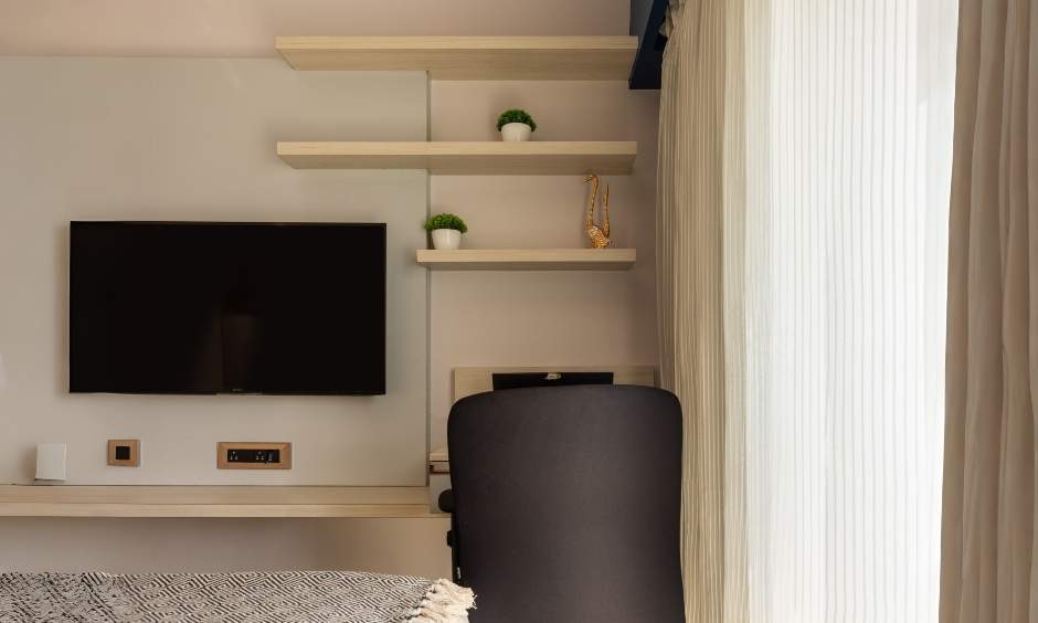 Minimalist study unit in light teak wood with floating shelves and wall-mounted TV in Kandivali West, Mumbai