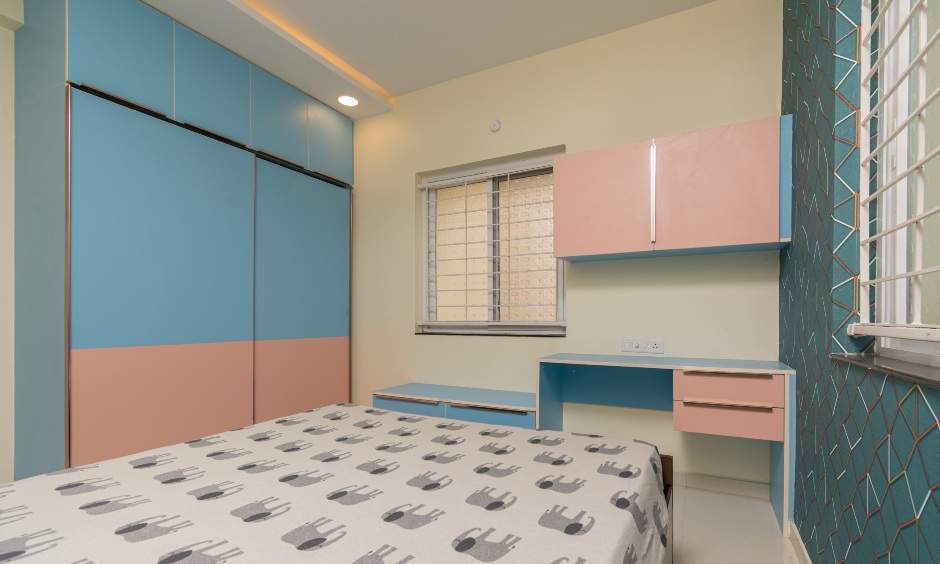 Kids bedroom interior in 3BHK Nizampet, Hyderabad by DesignCafe with pink-blue wardrobe