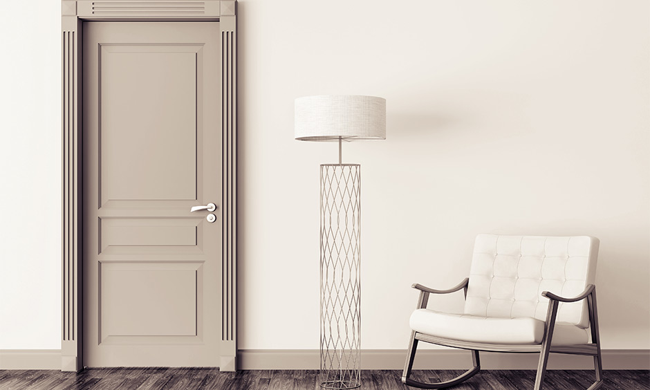 Light-coloured wooden bedroom door featuring traditional raised panels and detailed framing.