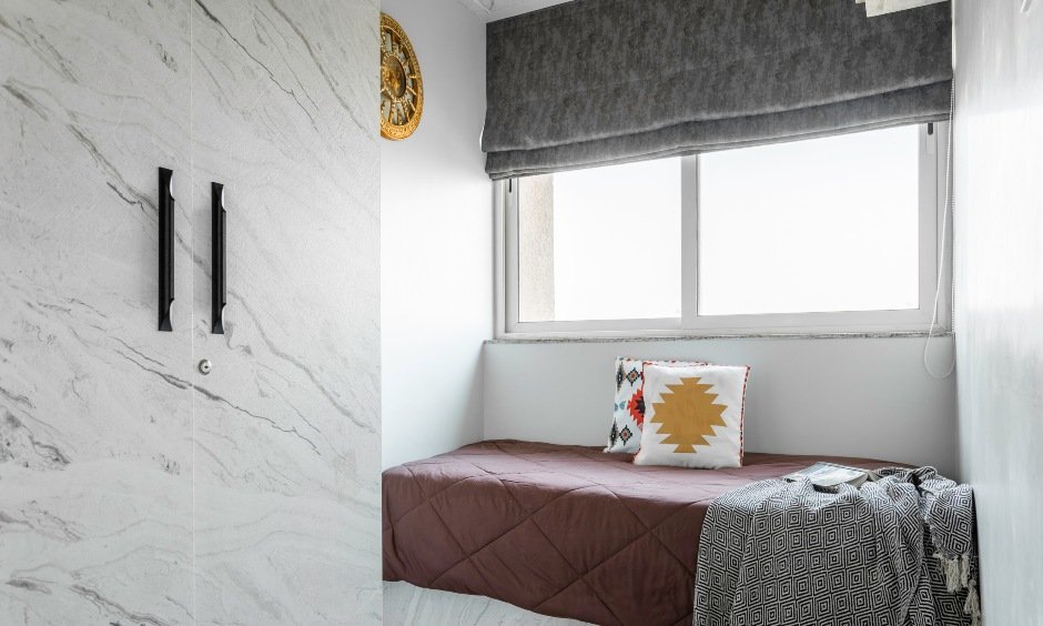 White kid's bedroom in Bhandup West with marble swing wardrobe & floating storage for toys