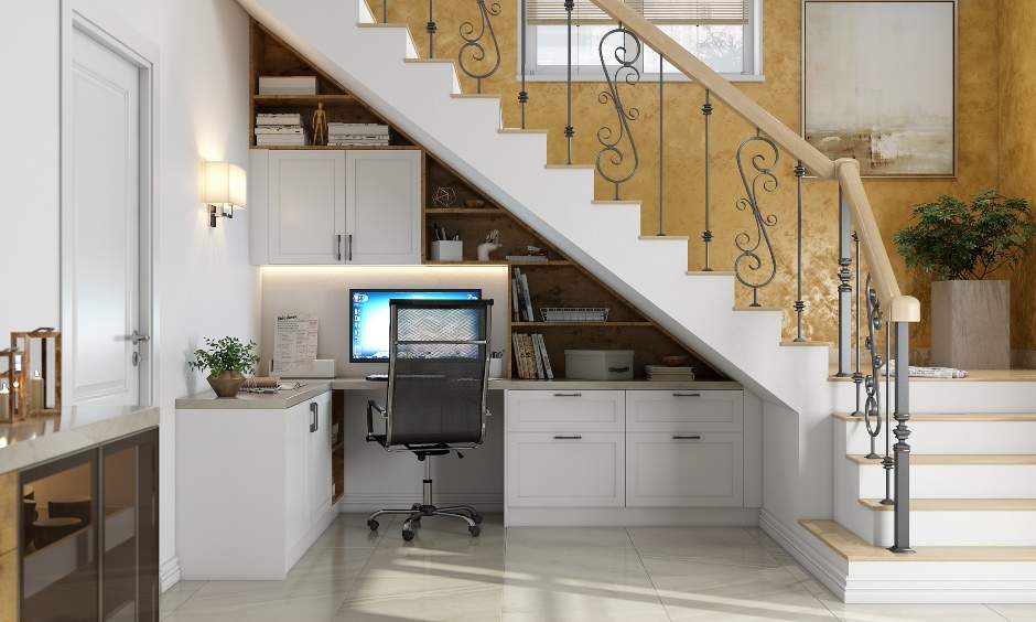 Space-saving home office setup under the stairs with an ergonomic chair provides a clutter-free