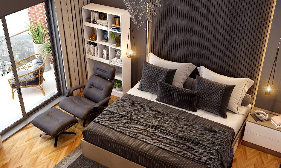A spacious black bedroom with bookshelf and black recliner chair