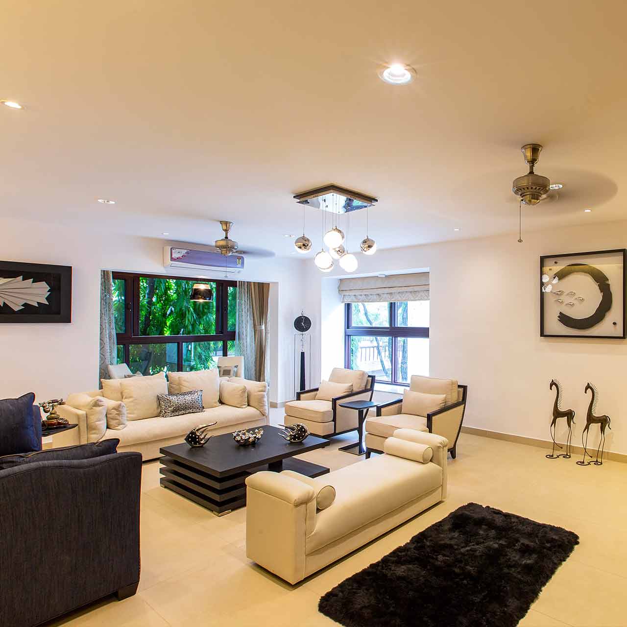 Traditional style living room design with elegant furnishing, textured rugs, bright statement lighting, and bright colour schemes