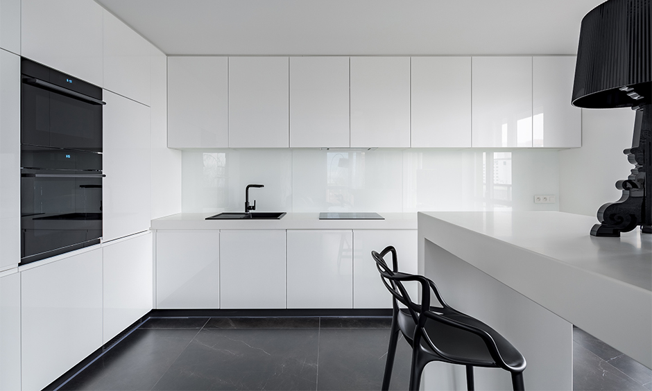 Sleek white back-painted glass kitchen with modern cabinets and glossy backsplash