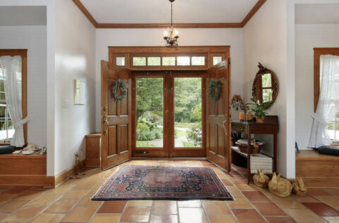 Elegant wood carving designs enhance the entrance of a home, showcasing intricate craftsmanship and inviting aesthetics